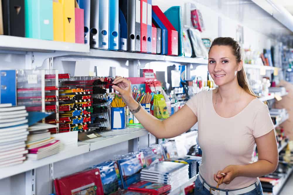 Emotional Female Buying Different Products In Stationery Shop